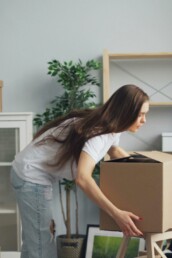 A woman unpacking moving boxes &mdash; expat support and transition therapy